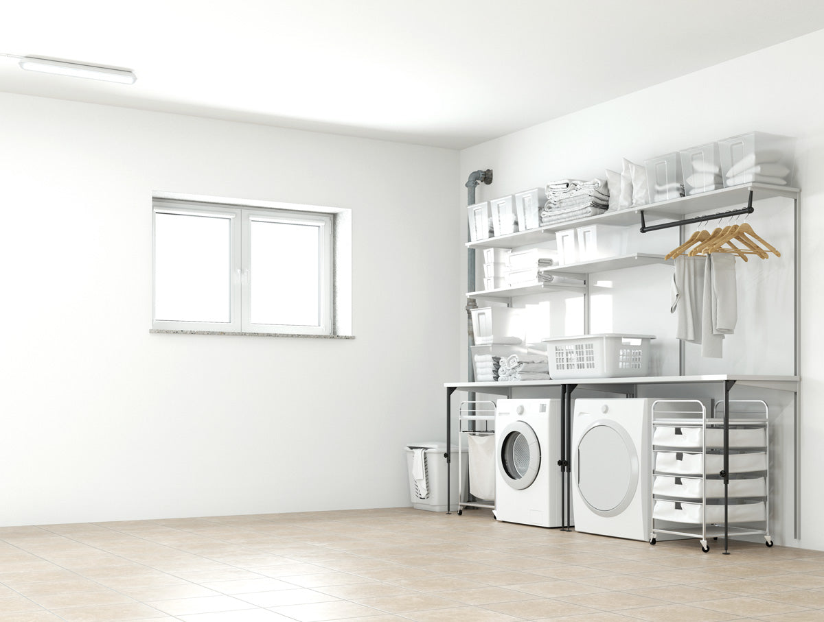 Hauswirtschaftsraum mit weißen Wänden, Waschmaschine, Trockner und Regalen.