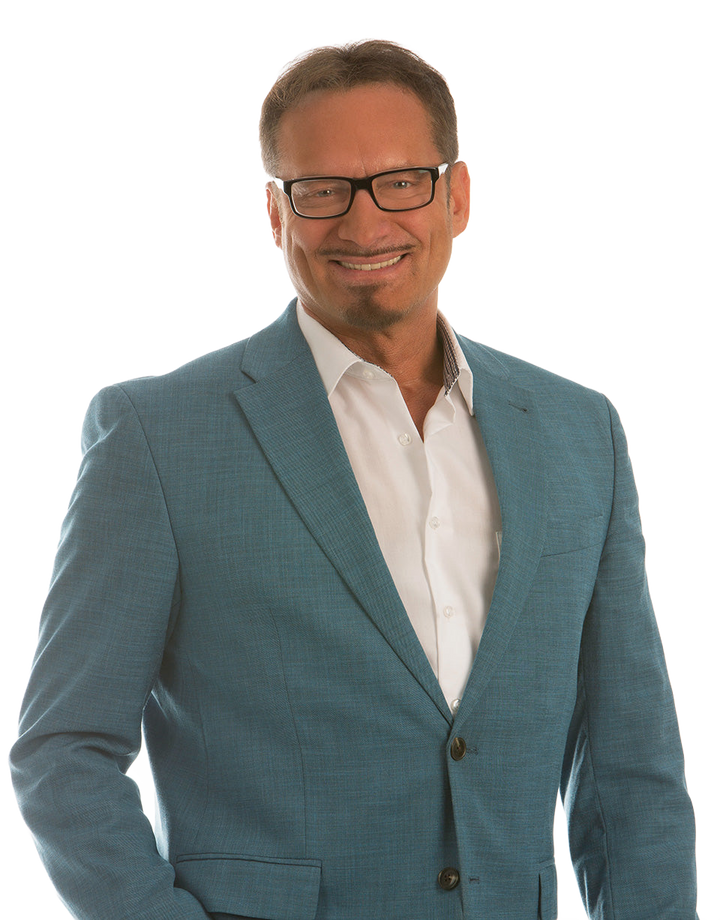 Peter Richter mit Brille im türkisfarbenen Sakko.